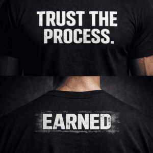Black t-shirt with white distressed text reading “Trust the Process” on the front and “Earned” on the back, worn by a model against a dark background.